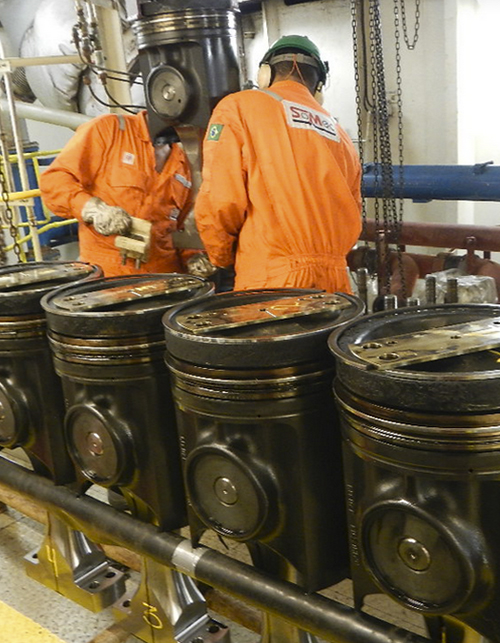 Homens de macacão laranja fazendo manutenção